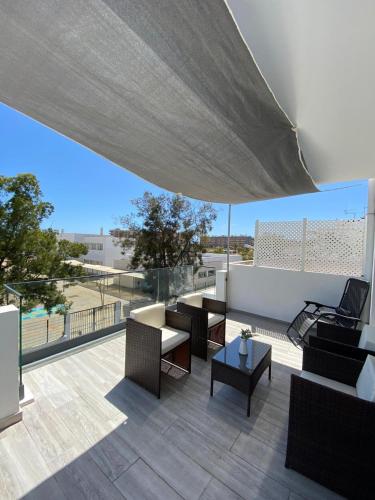a patio with furniture and a large umbrella at Apartment T2 Olhão in Olhão