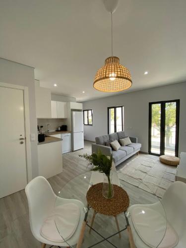 a living room with a table and white chairs at Apartment T2 Olhão in Olhão