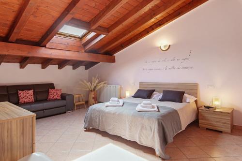 a bedroom with a large bed and a couch at Intelvi House in Castiglione dʼIntelvi