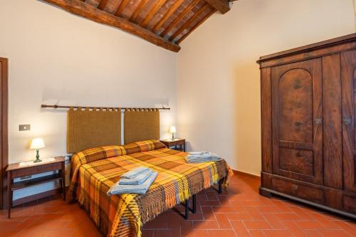 a bedroom with a bed and a wooden cabinet at Bella Toscana Relax in Monsummano Terme