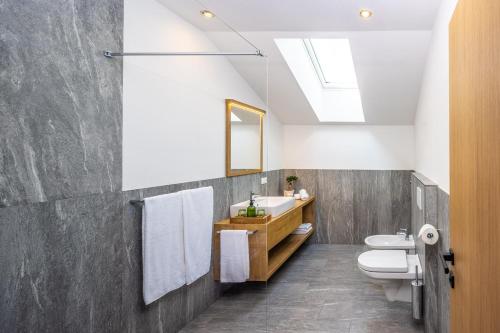 a bathroom with a sink and a toilet and a mirror at Zum Sonnentor App Pinus in Lutago