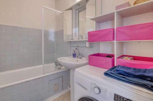 a bathroom with pink shelves and a sink and a tub at Chambre double à Toulouse in Toulouse