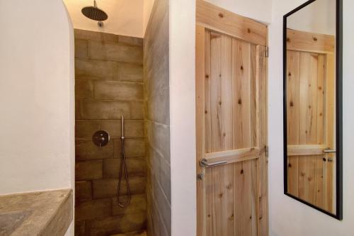 a bathroom with a shower and a wooden door at Casa Burro in Moncarapacho