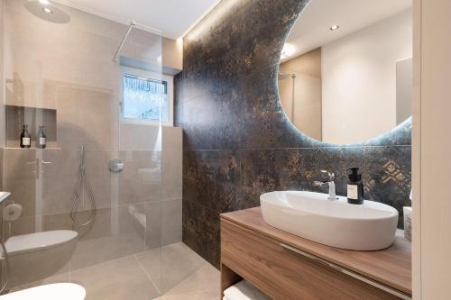 a bathroom with a sink and a mirror at New Opening Vinea Guesthouse in Cornedo all'Isarco