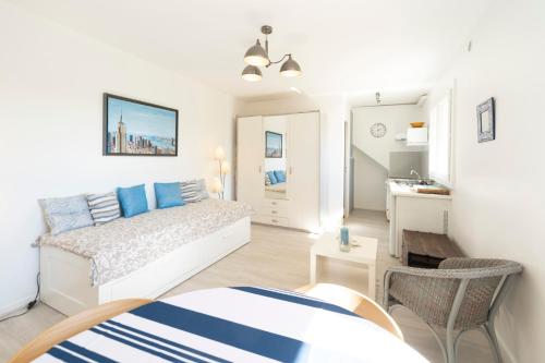 a white bedroom with a bed and a desk at Studio Proche Lac Hossegor in Hossegor