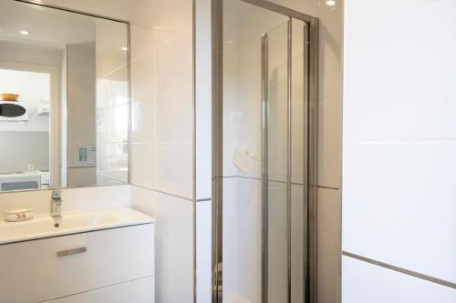a white bathroom with a sink and a shower at Studio Proche Lac Hossegor in Hossegor