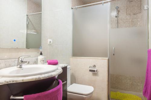 a bathroom with a sink and a shower with purple towels at Villa Julia in Rubí
