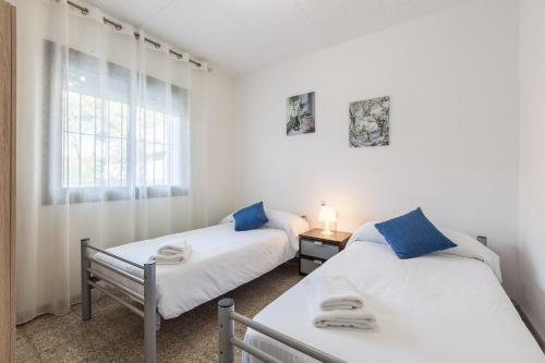 two beds in a room with a window at Villa Julia in Rubí