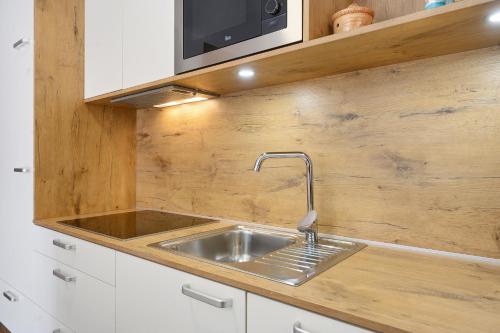 a kitchen with a sink and a microwave at Oberhemberger Hof Feldthurns in Feldthurns