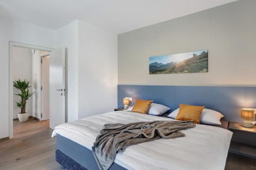 a bedroom with a king sized bed with a blue headboard at New Opening Vinea Guesthouse in Cornedo all'Isarco