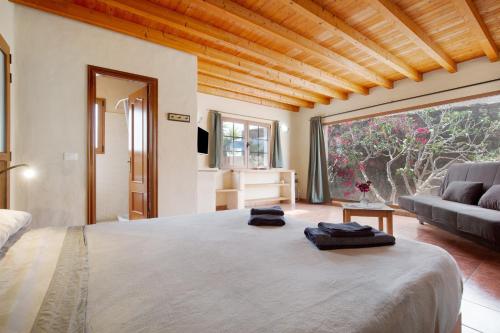 a bedroom with a large bed and a couch at Yukalele 2 in Lajares