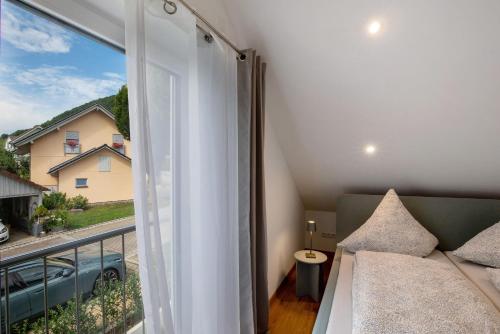 a living room with a couch and a large window at Ferienwohnung 6 in Bad Ditzenbach