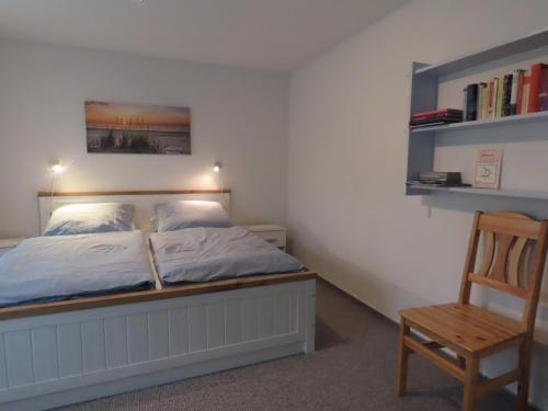 a bedroom with a bed and a wooden chair at Große Warf mit Rasenfläche in Ockholm