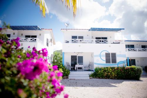 a white house with pink flowers in front of it at Marazul Dive Resort in Sabana Westpunt