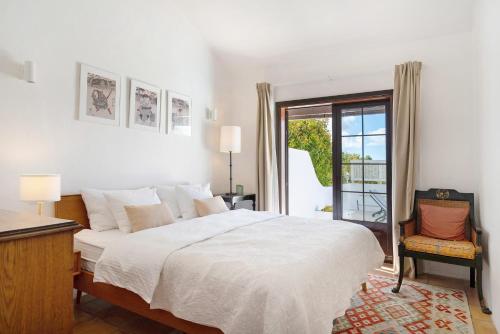 a white bedroom with a bed and a window at Casa Carmen - Comfort and Privacy in Nazaret