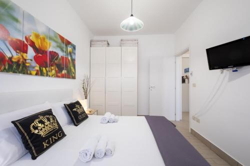 a bedroom with a white bed and a flat screen tv at Areon - Central Coastal Residence in Porto Cesareo