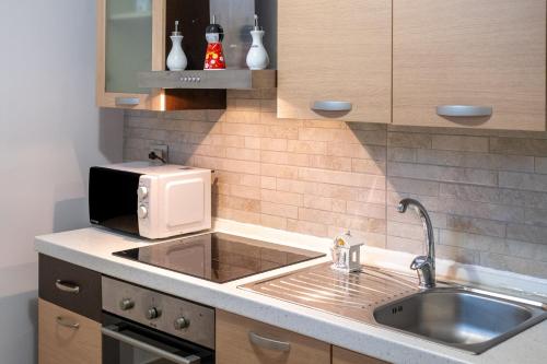 a kitchen with a sink and a microwave at Areon - Central Coastal Residence in Porto Cesareo