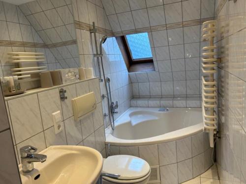 a bathroom with a tub and a toilet and a sink at Ferienhaus Waldeck in Marienberg