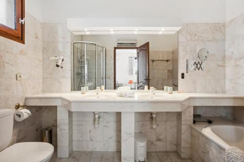 a bathroom with a sink and a tub and a toilet at Villa Elisabeth in Fréjus