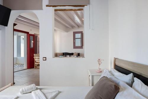a white bedroom with a bed and a living room at Nicolas House 2 in Rakhídhion
