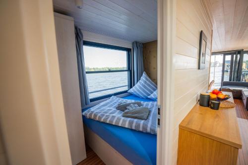 a small room with a blue bed and a window at Exklusives Naturerlebnis Roxy in Fürstenberg
