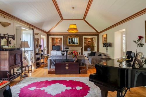 a living room with a pink rug and a piano at Quinta de Amares in Amares