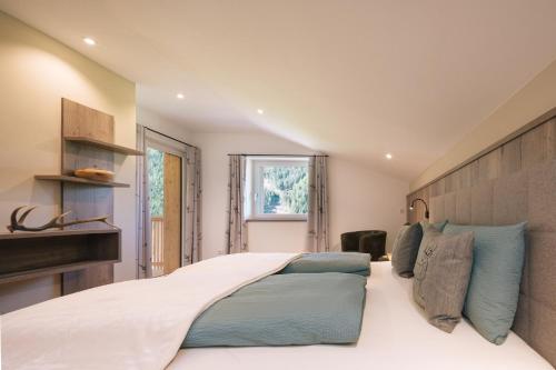 a bedroom with a large white bed with blue pillows at Balbeinhof Apt Hirsch in Luson