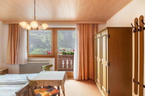 a bedroom with a bed and a table and a window at Ferienwohnung Dornauer Sommer in Hippach