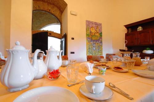 a table with white vases and plates on it at Villa Arnilù in San Gimignano