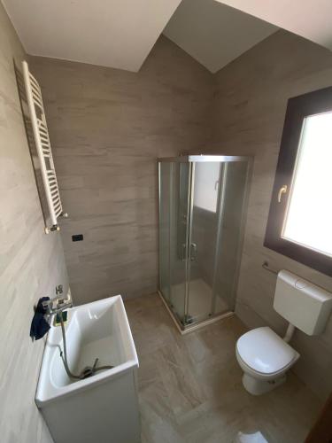 a bathroom with a shower and a toilet and a sink at Dall'alba al Tramonto in Alezio