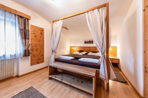 a bedroom with a bed with a swing at Florerhof Ferienwohnung Lavendel in Vols am Schlern
