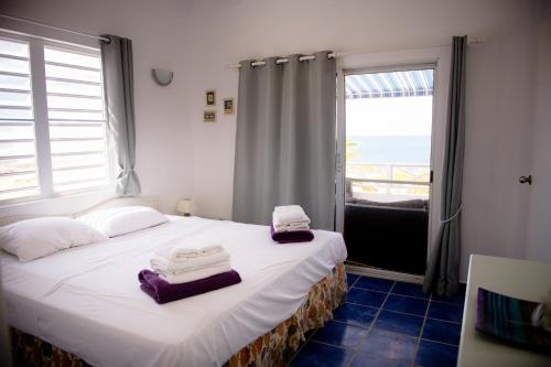 a bedroom with a bed with towels on it at Marazul Dive Resort in Sabana Westpunt