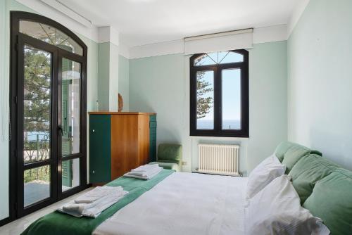 a bedroom with a bed and two windows at Capriccio in Bordighera