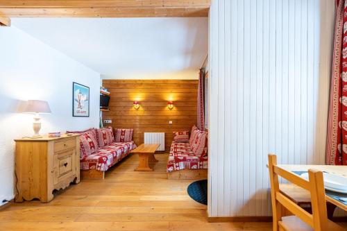 a living room with red chairs and a table at Lauziere dessus 50 in Valmorel