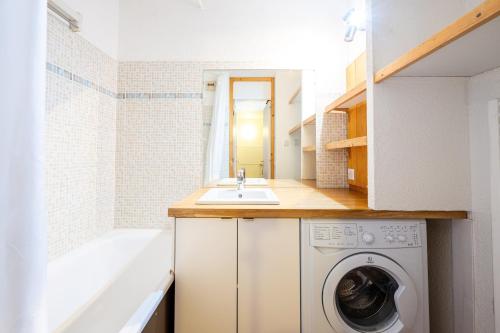 a small bathroom with a washing machine and a sink at Lauziere dessus 50 in Valmorel