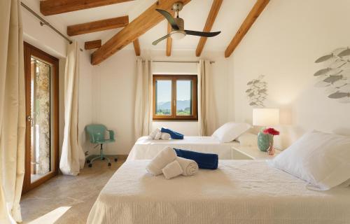 a bedroom with two beds and a ceiling fan at Finca Playa Llenaire - Can Pou in El Port