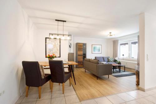a dining room and living room with a table and chairs at Waldmariechen in Neresheim