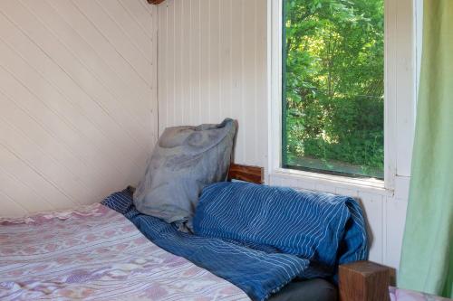 a bed in a room with a window and a pillow at Ferien Tinyhaus im Tale in Ascheffel