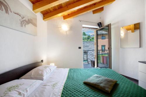 a bedroom with a bed with a green blanket on it at La Maison De Carletto in Sarre