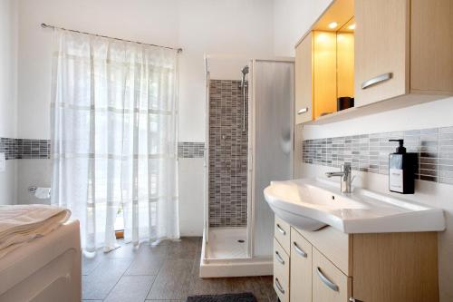 a white bathroom with a sink and a shower at La Maison De Carletto in Sarre