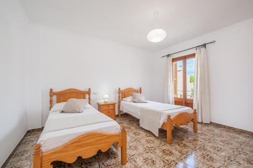 ein Schlafzimmer mit zwei Betten und einem Fenster in der Unterkunft C'an Crespí in Consell