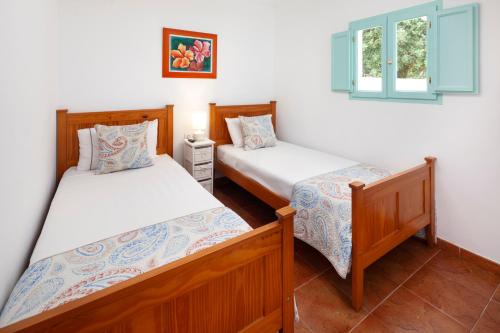 a bedroom with two beds and a window at La Casita del Limoncito in Alcaucín