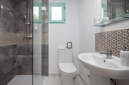 a bathroom with a toilet and a sink and a shower at La Casita del Limoncito in Alcaucín