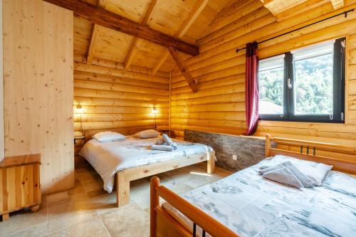 a bedroom with two beds in a log cabin at Chalet Agréable 3 étoiles app 4 in Courchevel