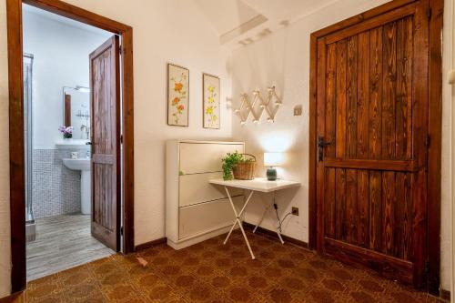 a bathroom with a sink and a table and a door at Casa al mare con ampia veranda in Stintino
