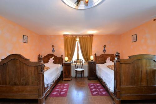 a bedroom with two beds and a window at Les Pruniers - Orbey in Orbey