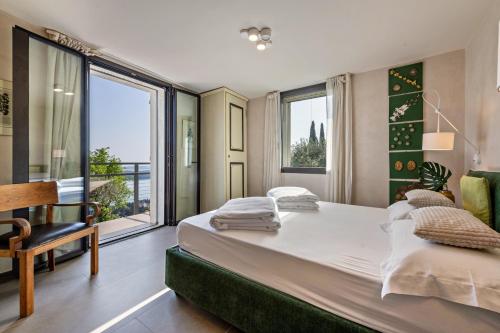 a bedroom with a large bed and a large window at Villa Artista in Gardone Riviera
