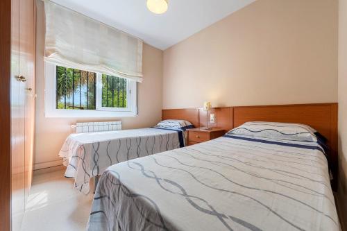 two beds in a room with a window at Creixell in Creixell