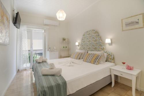 a white bedroom with a large bed and a window at M2 room in Nikiana