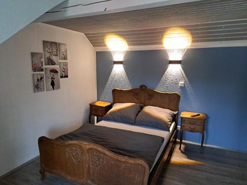 a bedroom with a bed with two lights on the wall at Zimmer in Müsch nahe Nürburgring in Müsch